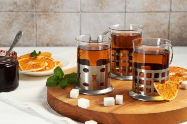 Beyaz ahşap masada servis edilen metal tutacaklı çay bardakları