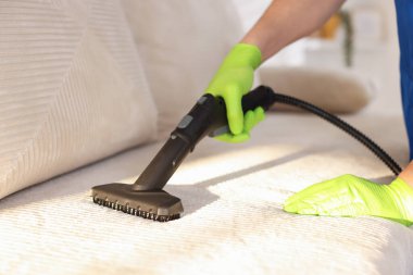 Profesyonel temizlikçi kanepede buhar sistemi var, yakın çekim.