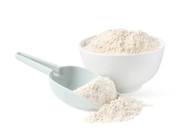 Kahverengi pirinç unu kasede ve kepçeyle beyaz üzerine izole edilmiş