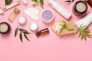 Pembe arka planda farklı vücut bakım ürünleri bulunan düz kompozisyon. Metin için boşluk