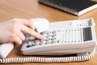 Ahşap masada telefonla arayan kadın, yakın plan.