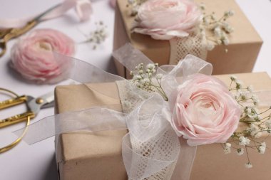 Çiçekçi. Beyaz arkaplanda kutular, çiçekler, kurdele ve makas, yakın plan