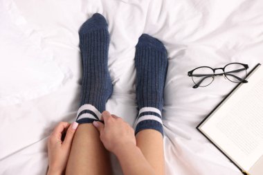 Yatakta mavi çorap giyen bir kadın.