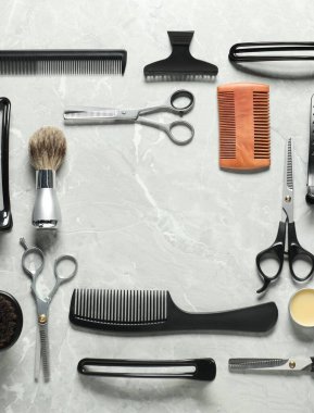 Açık gri masadaki birçok farklı berber aletinden yapılmış çerçeve düz yatıyordu. Metin için boşluk