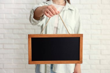 Elinde boş, küçük bir tahta tutan kadın, yakın plan.