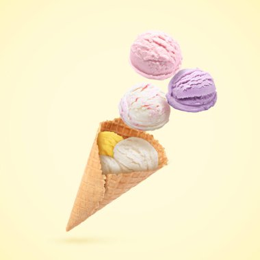Dondurma kepçeleri ve bej arka planda havada waffle külahı