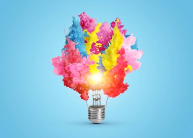 Fikir konsepti. Açık mavi arka planda parlayan ampulden parlayan parlak boya damlaları