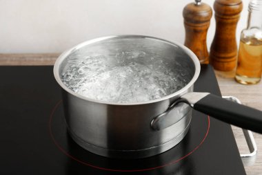 Kaynar suyla tencere ve soba ahşap masa üzerinde beyaz arka plan, yakın çekim