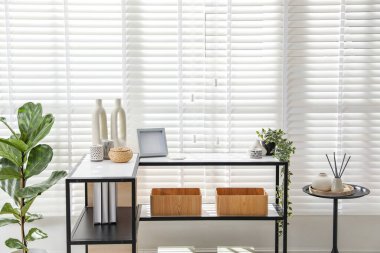 Pencerenin yanında farklı dekorları olan konsol masası. İç tasarım