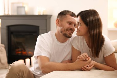 Mutlu çift, şık şömineli bir odada birlikte vakit geçiriyor.