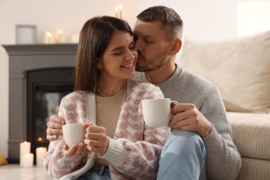 Evde sıcak bir şeyler içen mutlu bir çift.