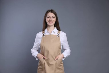 Gri arka planda gülümseyen baristanın portresi