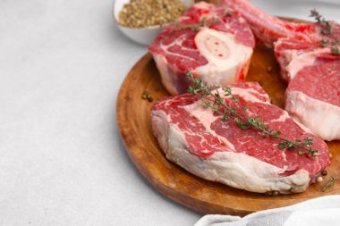 Çiğ et ve baharat parçaları açık gri masada, yakın plan. Metin için boşluk