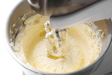 Beyaz masada çırpılmış kremayla karıştırma, yakın plan.