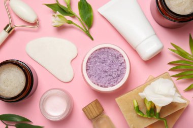 Pembe arka planda farklı vücut bakım ürünleriyle düz konum