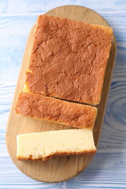 Lezzetli Japon Castella sünger kek açık mavi ahşap masa, üst manzara