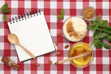 Boş tarif kitabı, tatlı ve malzemeler kırmızı kareli peçete üzerinde, düz uzanmış