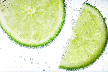 Beyaz arka planda limon dilimli soda, yakın plan.