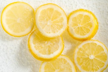 Arka planda limon dilimleri olan soda, yakın plan.