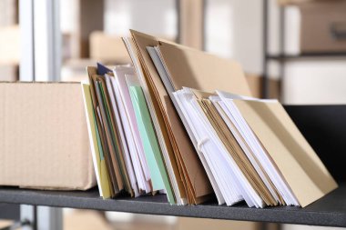 Postanedeki raflarda bir sürü farklı zarf ve paket var.