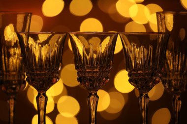 Bulanık ışıklara karşı birçok temiz bardak, yakın plan. Bokeh etkisi