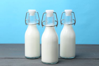 Tahta masada açık mavi arka plana karşı taze süt.