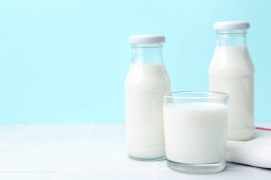 Açık mavi arka planda beyaz masada taze süt. Metin için boşluk