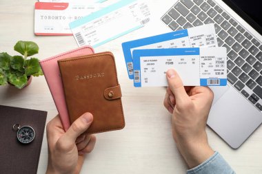 Seyahat acentesi. Uçuş biletleri ve pasaportu olan bir adam açık tahta masada, üst tarafta.