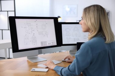 Ofisteki masada dijital çizimlerle çalışan mühendis