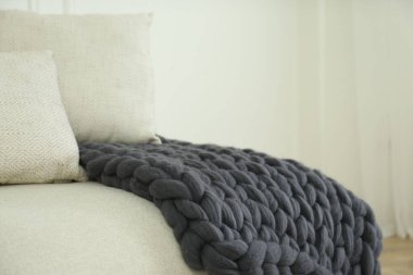 Odadaki kanepede örülmüş merino yün ekose.