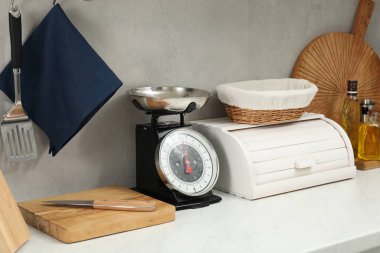 Retro mechanical kitchen scale and other utensils on white countertop indoors