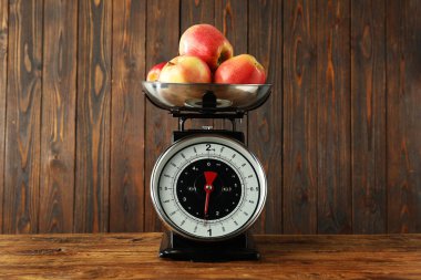 Retro mechanical kitchen scale with apples on wooden table