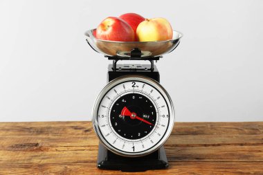 Retro mechanical kitchen scale with apples on wooden table