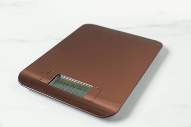 Modern elektronik mutfak terazisi beyaz mermer masa, yakın plan.