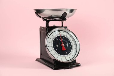 One mechanical kitchen scale on pink background