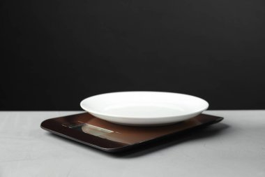 Gri desenli tablolu plakalı elektronik mutfak terazisi siyah arka planda