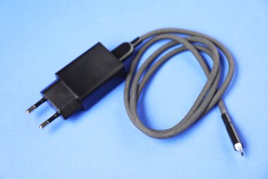 Mavi arkaplanda şarj kablosu olan USB güç adaptörü, kapat