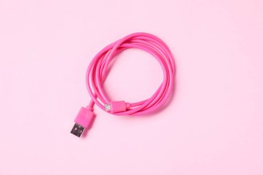 Soluk pembe arkaplanda bir USB şarj kablosu, üst görünüm