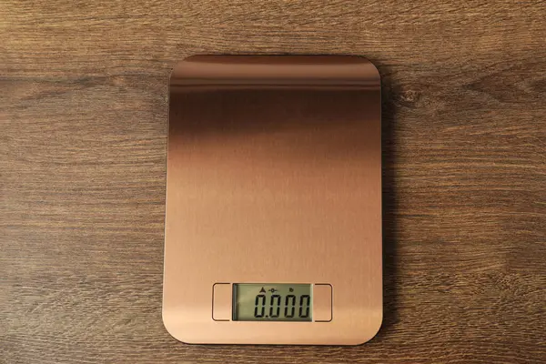 Modern elektronik mutfak terazisi ahşap masa, üst manzara.