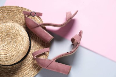 Renkli arka planda bir çift şık ayakkabı ve hasır şapka. Metin için boşluk