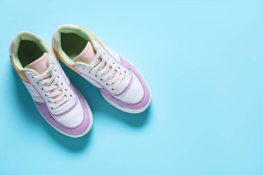 Açık mavi arka planda bir çift şık spor ayakkabı, üst manzara. Spor ayakkabılar.