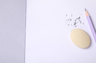 Silgi, kalem ve kırıntılar deftere, düz konum. Metin için boşluk