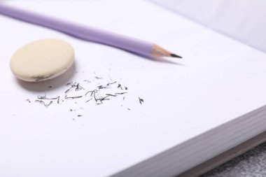 Silgi, kalem, defter ve kırıntılar masada, yakın plan