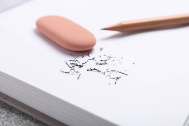 Silgi, kalem, defter ve kırıntılar masada, yakın plan