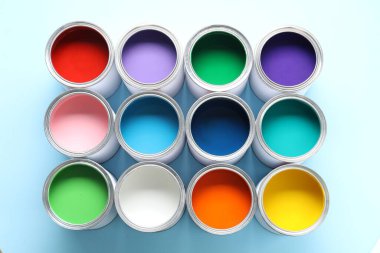 Açık mavi arkaplanda farklı boya kutuları, üst görünüm