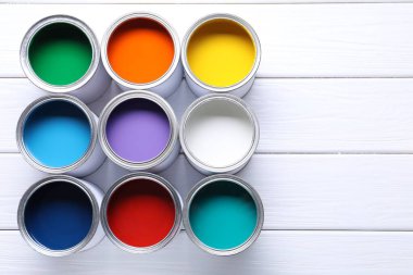 Beyaz ahşap masa üzerinde parlak boya kutuları, düz yatıyordu. Metin için boşluk
