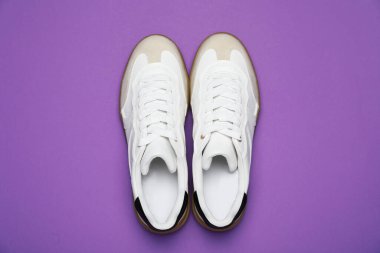 Pair of stylish sneakers on purple background, flat lay. Casual shoes