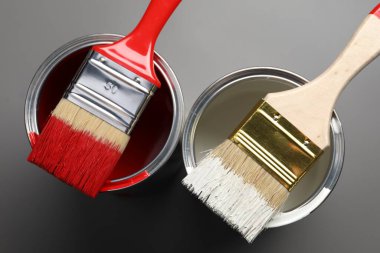 Gri arka planda boya ve fırça kutuları, üst görünüm