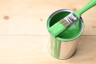 Ahşap masa üzerinde yeşil boya ve fırça kutusu, yakın plan. Metin için boşluk