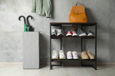 Ayakkabı deposu. Farklı ayakkabı, sırt çantası ve şemsiyeli raf ünitesi.